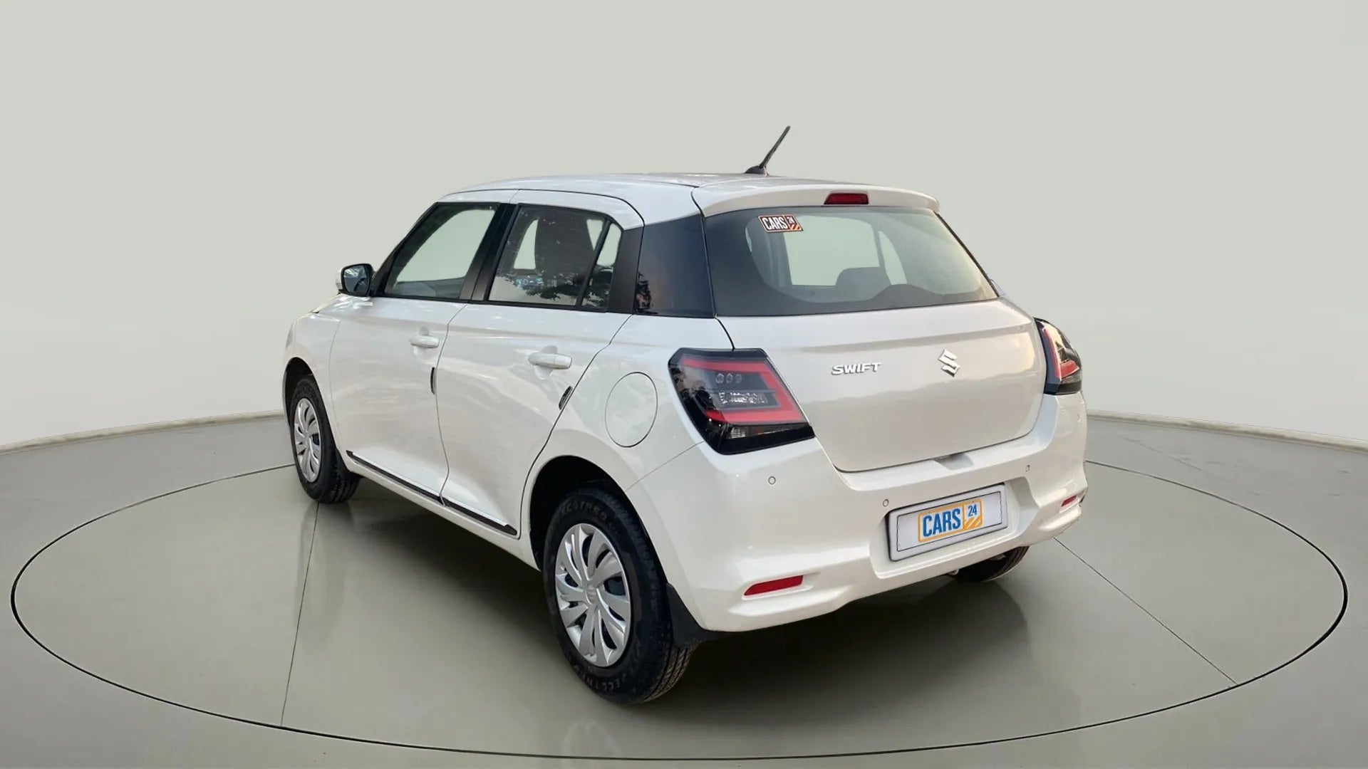 Rear three-quarter view of a Pearl Arctic White with Pearl Midnight Black Maruti Suzuki Swift