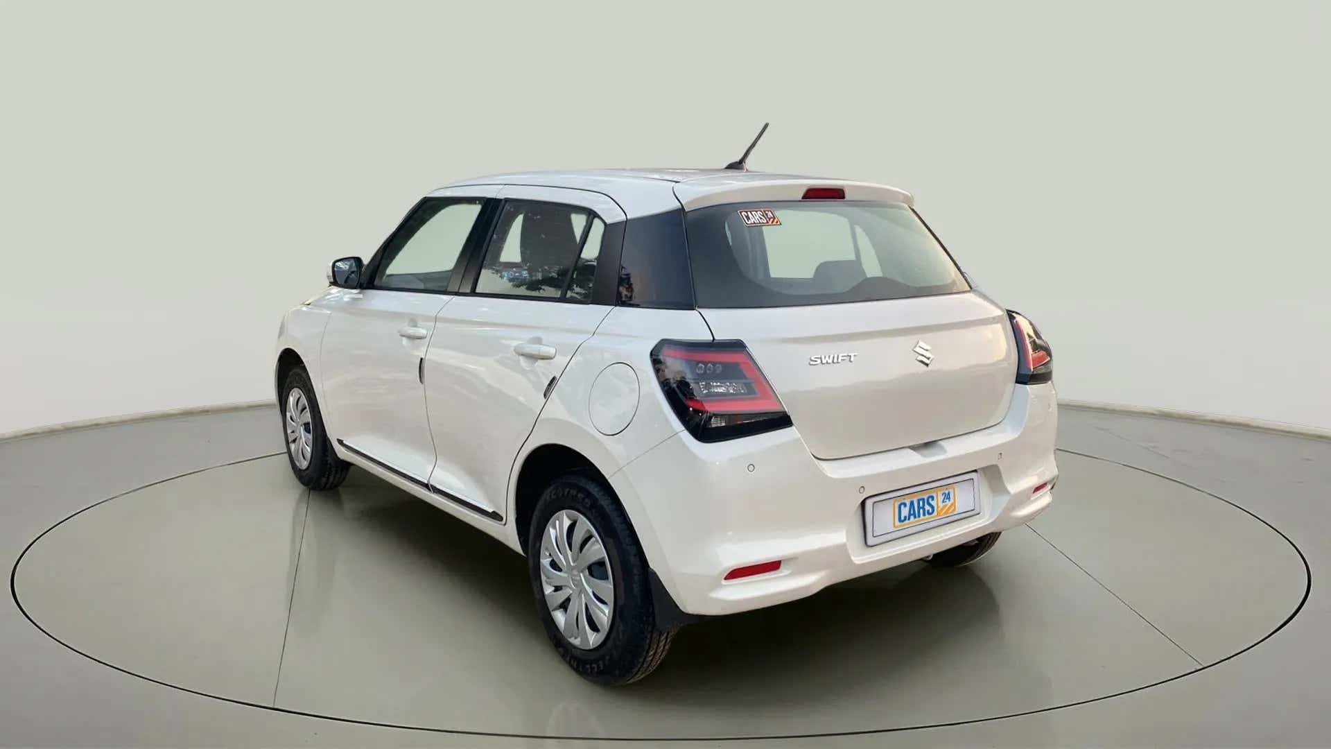 Rear three-quarter view of a Pearl Arctic White with Pearl Midnight Black Maruti Suzuki Swift