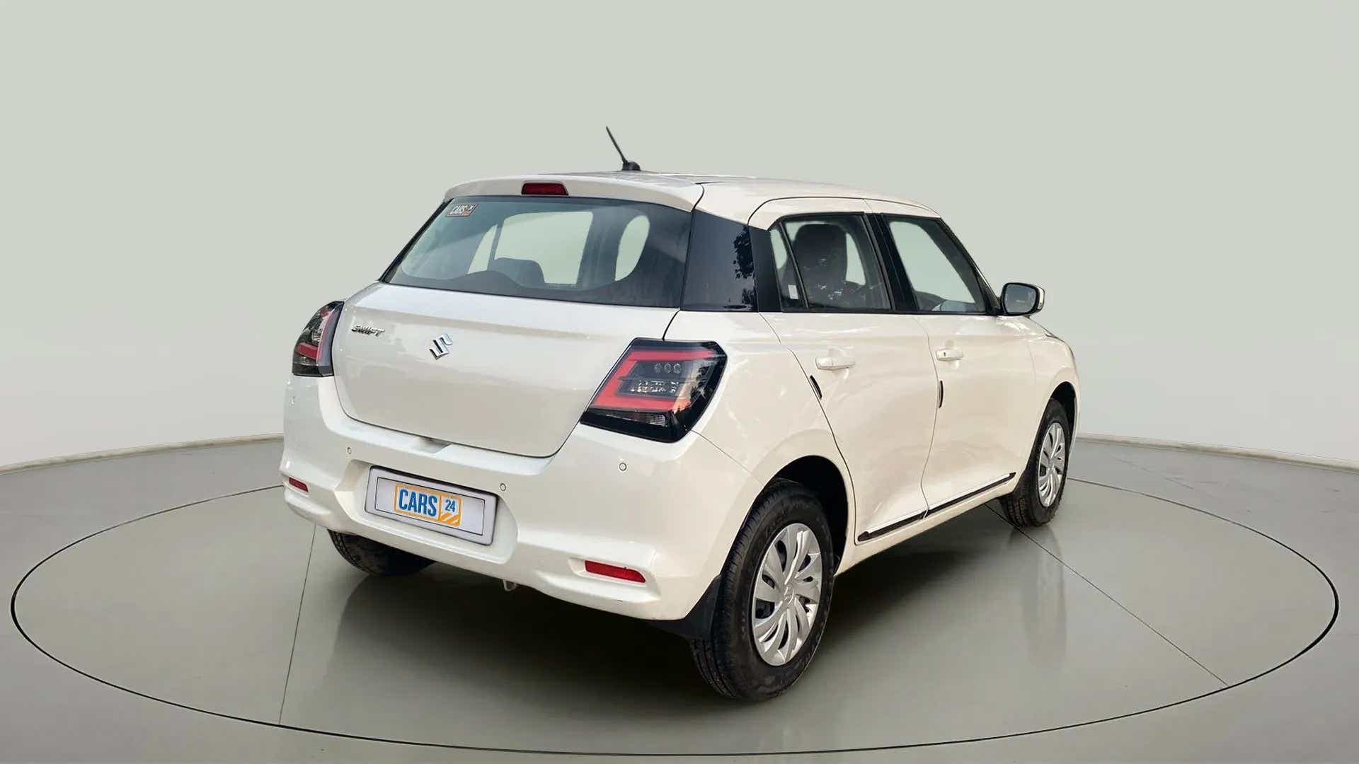 Rear three-quarter view of a Pearl Arctic White with Pearl Midnight Black Maruti Suzuki Swift