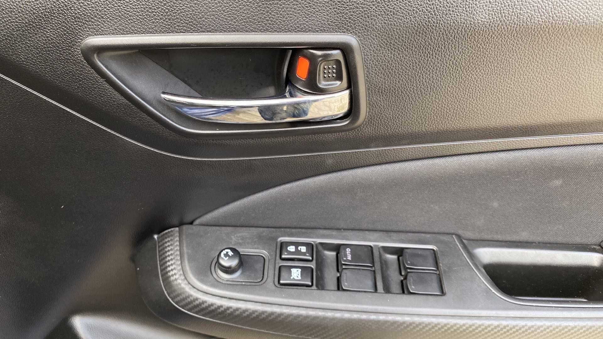 Driver-side door handle and controls of a Maruti Suzuki Swift 2021 - 2023