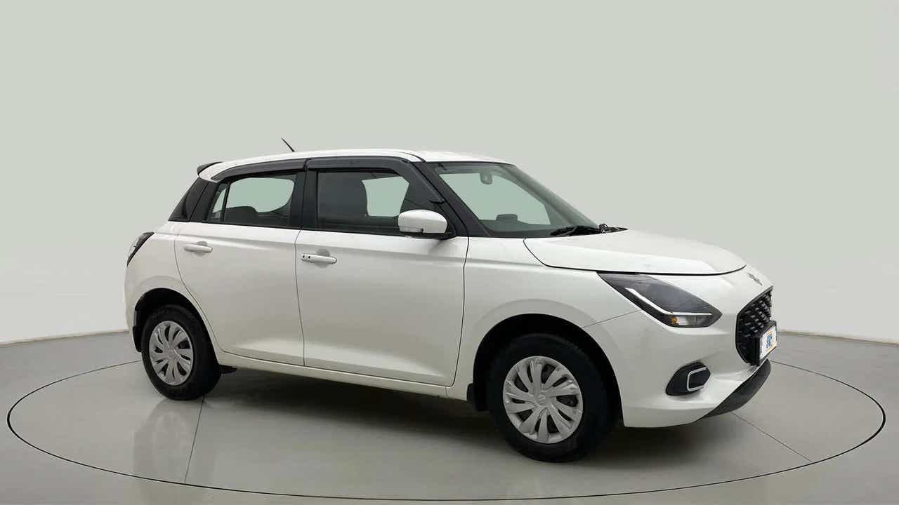 Front and side view of a pearl arctic white with pearl midnight black Maruti Suzuki Swift