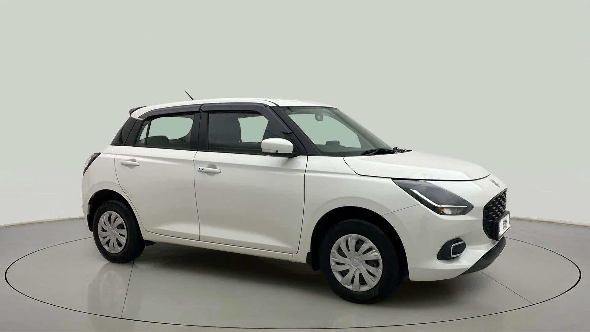 Front and side view of a pearl arctic white with pearl midnight black Maruti Suzuki Swift