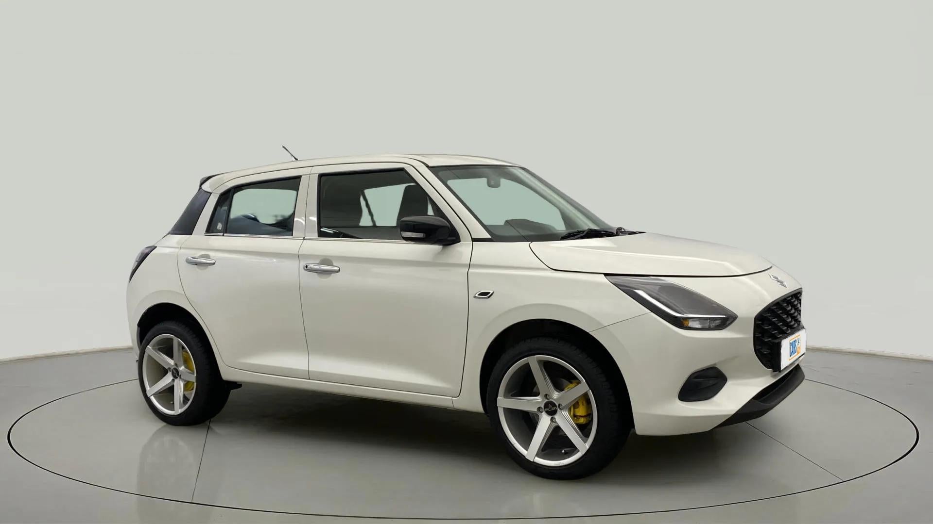 Front three-quarter view of a Pearl Arctic White with Pearl Midnight Black Maruti Suzuki Swift