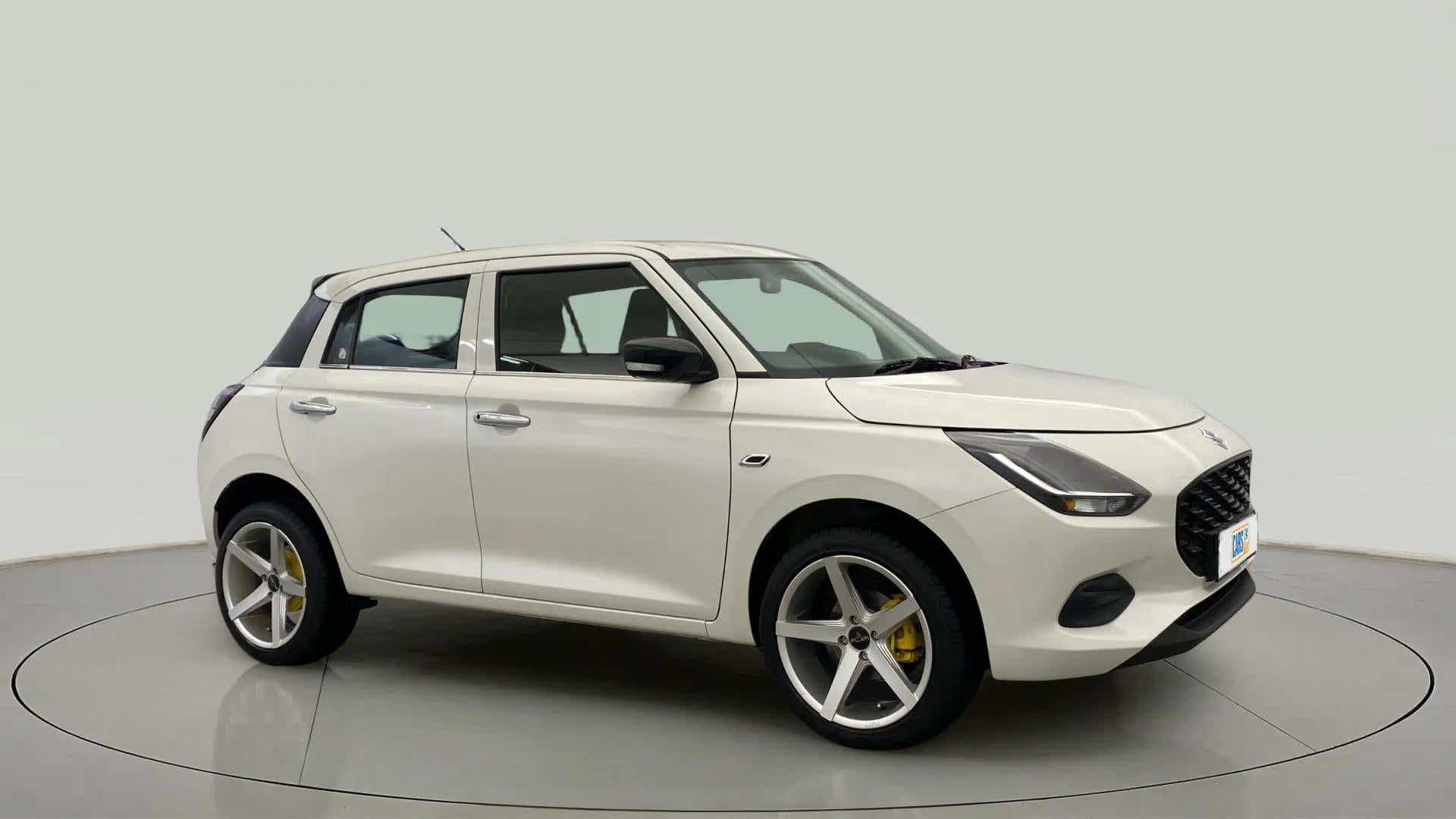 Front three-quarter view of a Pearl Arctic White with Pearl Midnight Black Maruti Suzuki Swift