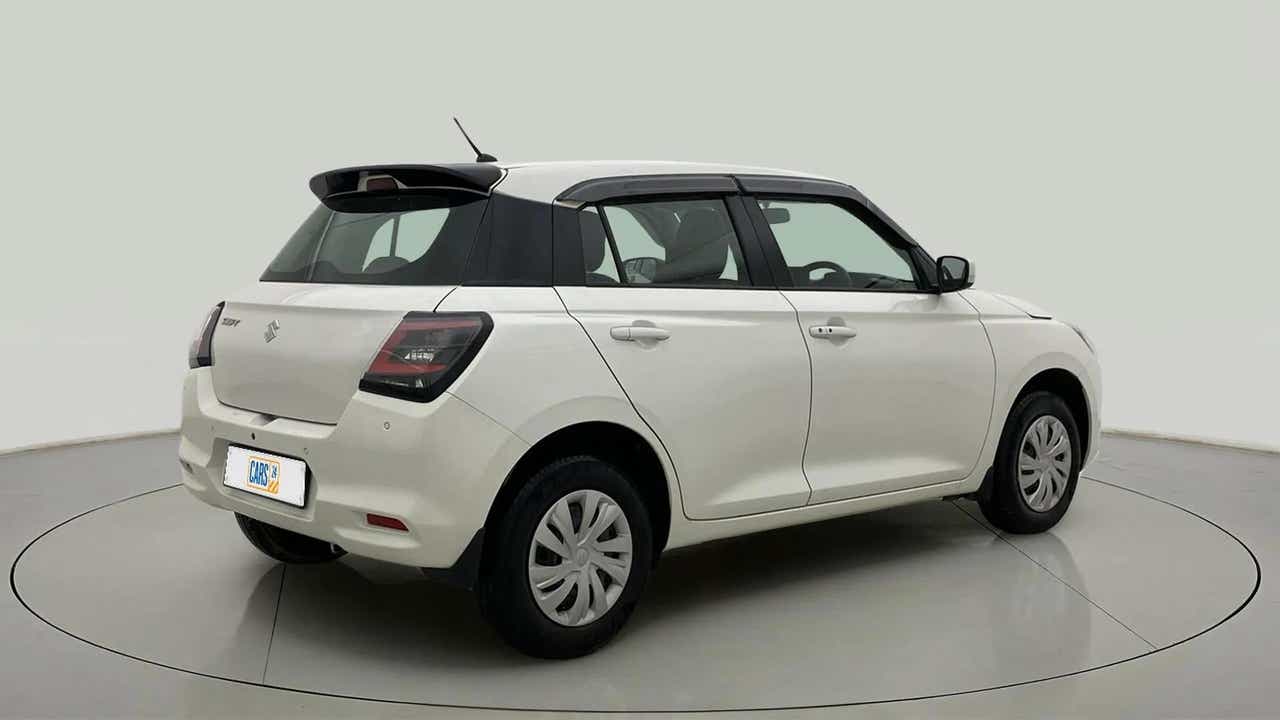 Rear three-quarter of a Pearl Arctic White with Pearl Midnight Black Maruti Suzuki Swift