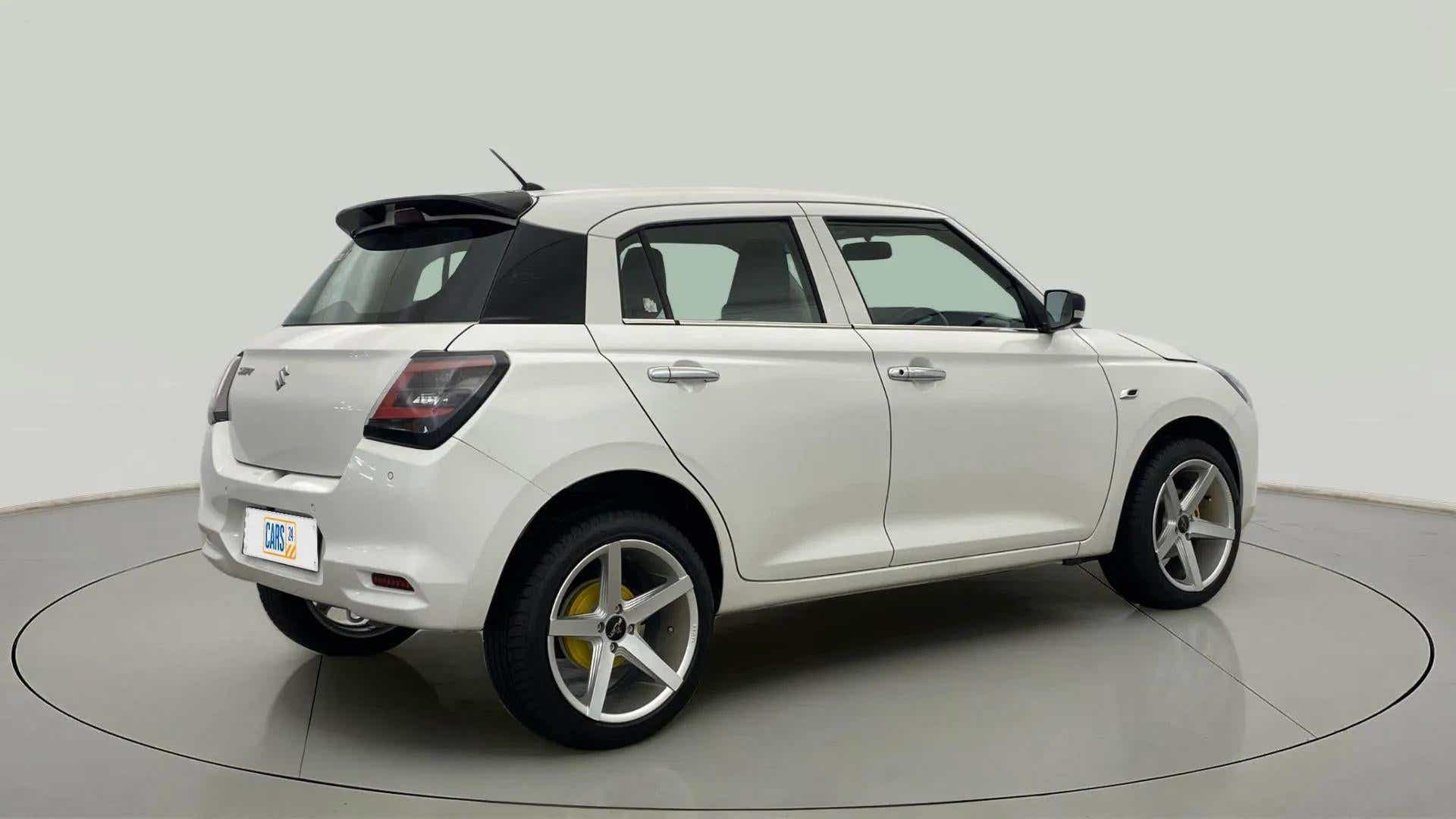 Rear three-quarter view of a Pearl Arctic White with Pearl Midnight Black Maruti Suzuki Swift