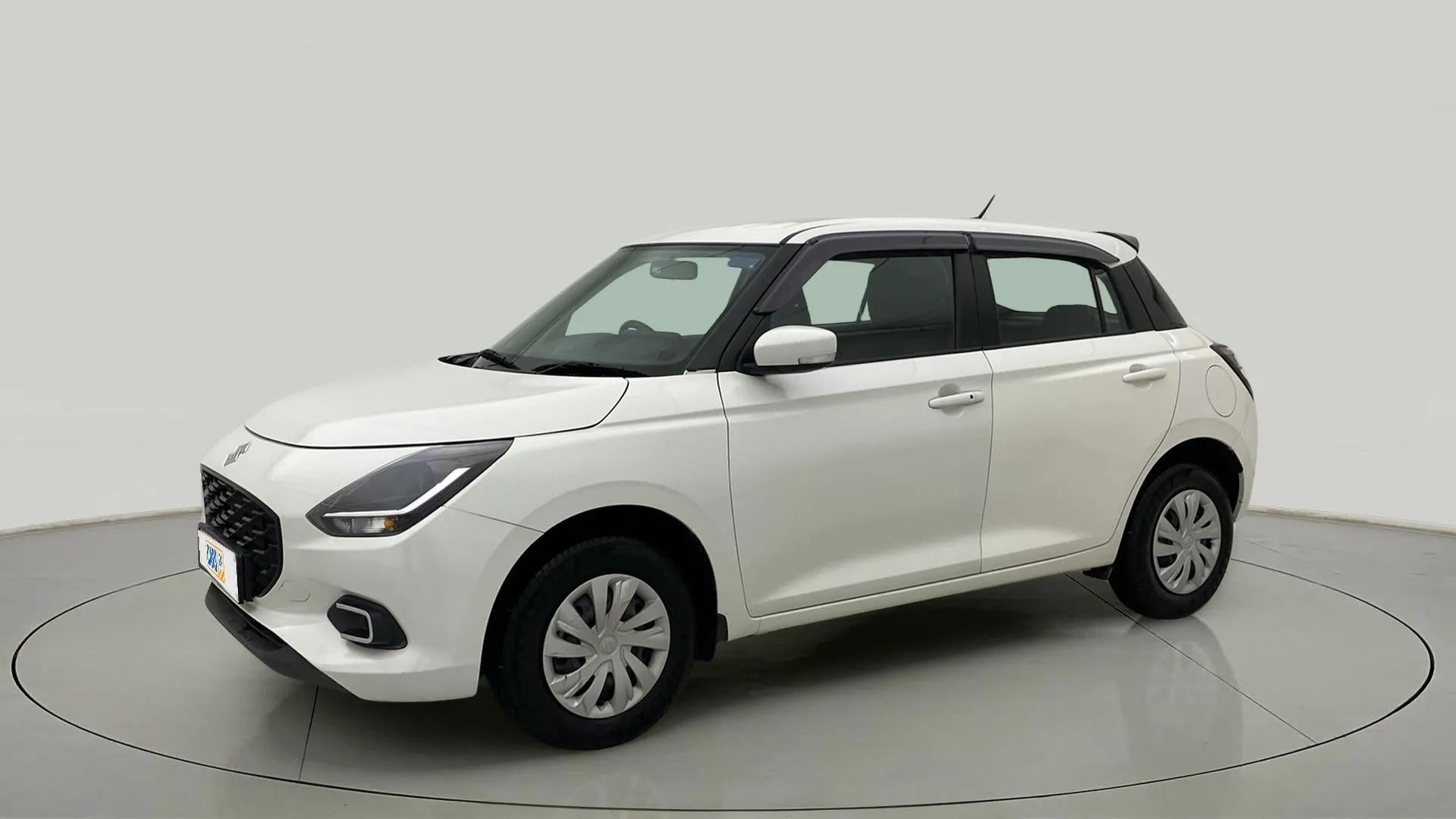 Front three-quarter view of a Pearl Arctic White with Pearl Midnight Black Maruti Suzuki Swift
