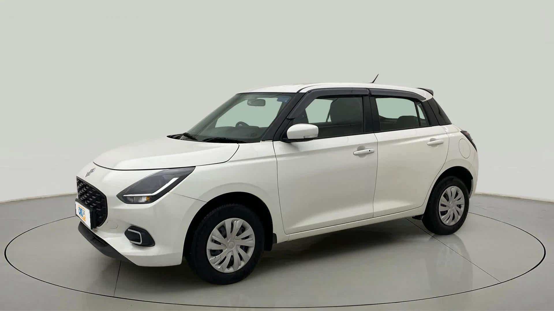 Front three-quarter view of a Pearl Arctic White with Pearl Midnight Black Maruti Suzuki Swift