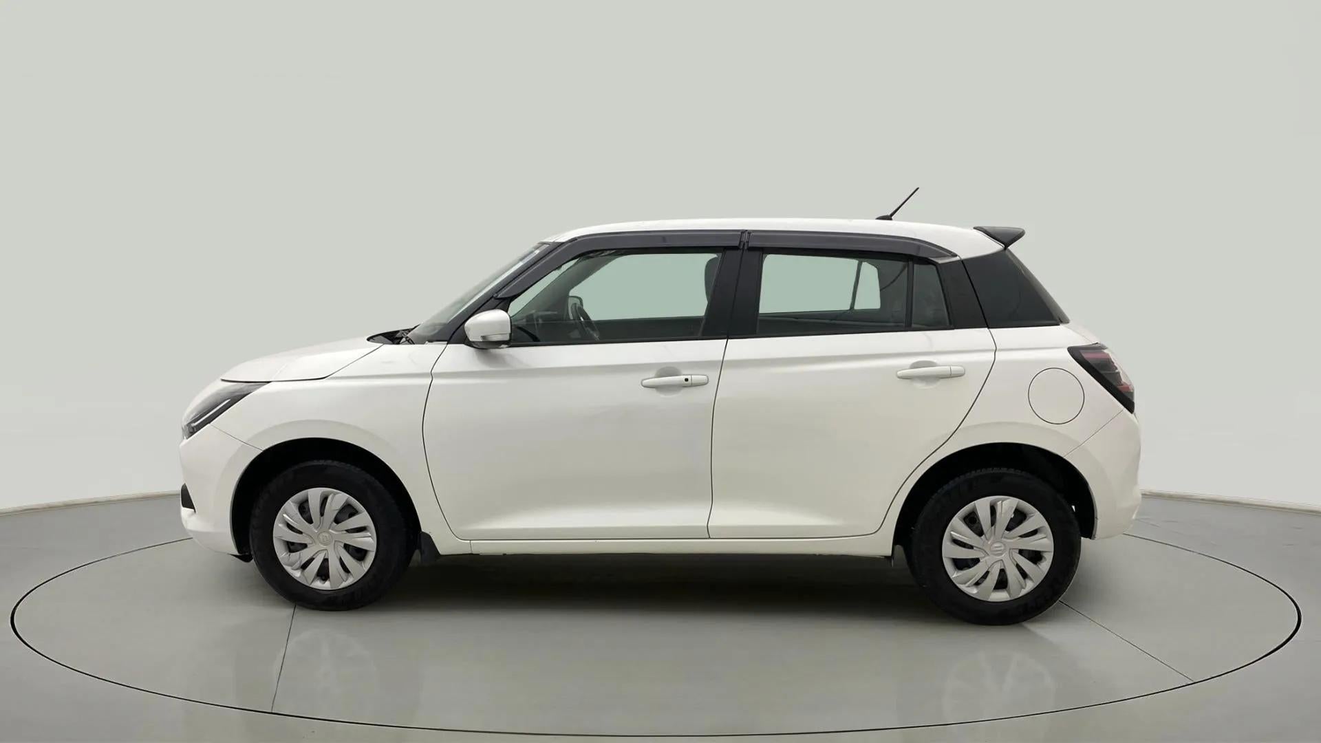 Left side view of a Pearl Arctic White with Pearl Midnight Black Maruti Suzuki Swift