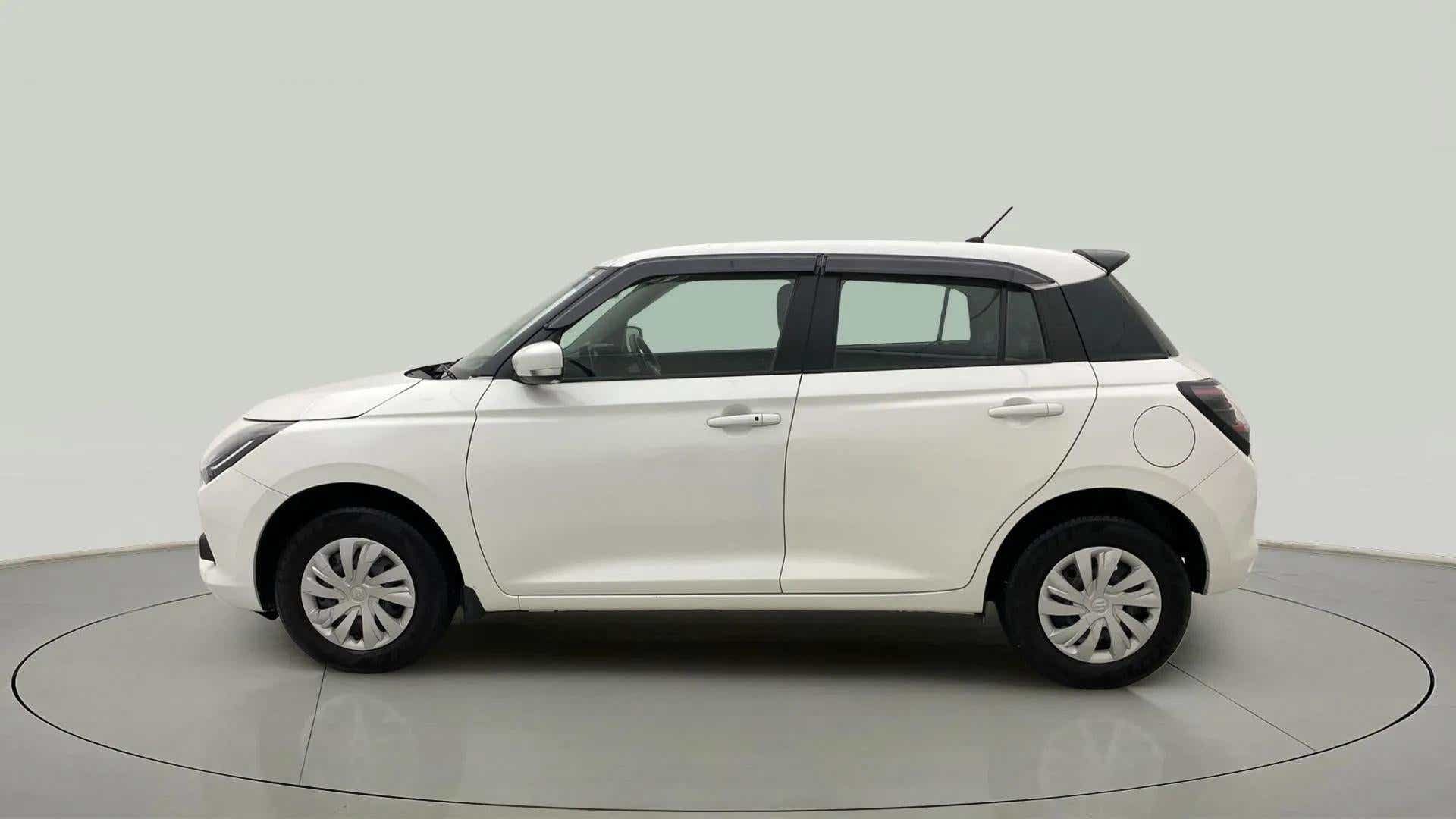 Left side view of a Pearl Arctic White with Pearl Midnight Black Maruti Suzuki Swift