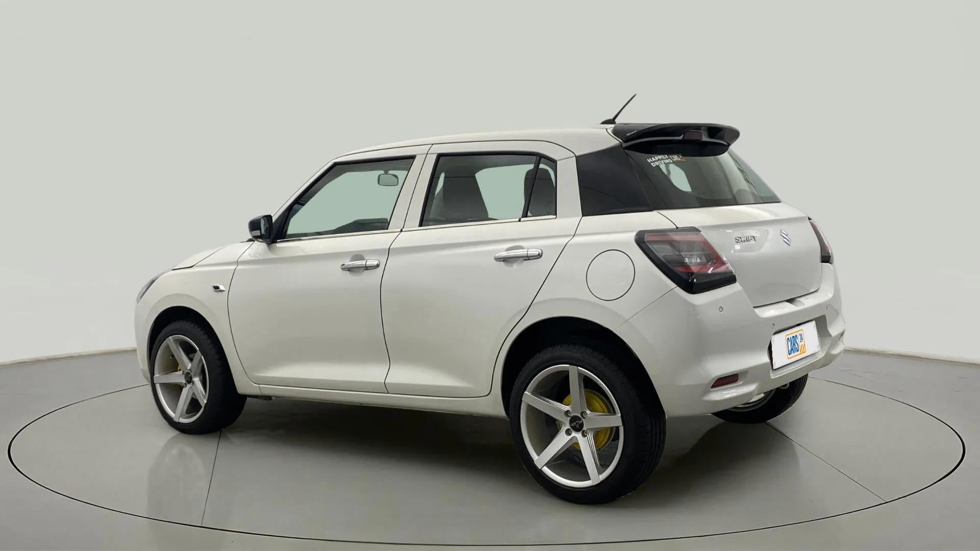Rear three-quarter view of a Pearl Arctic White with Pearl Midnight Black Maruti Suzuki Swift