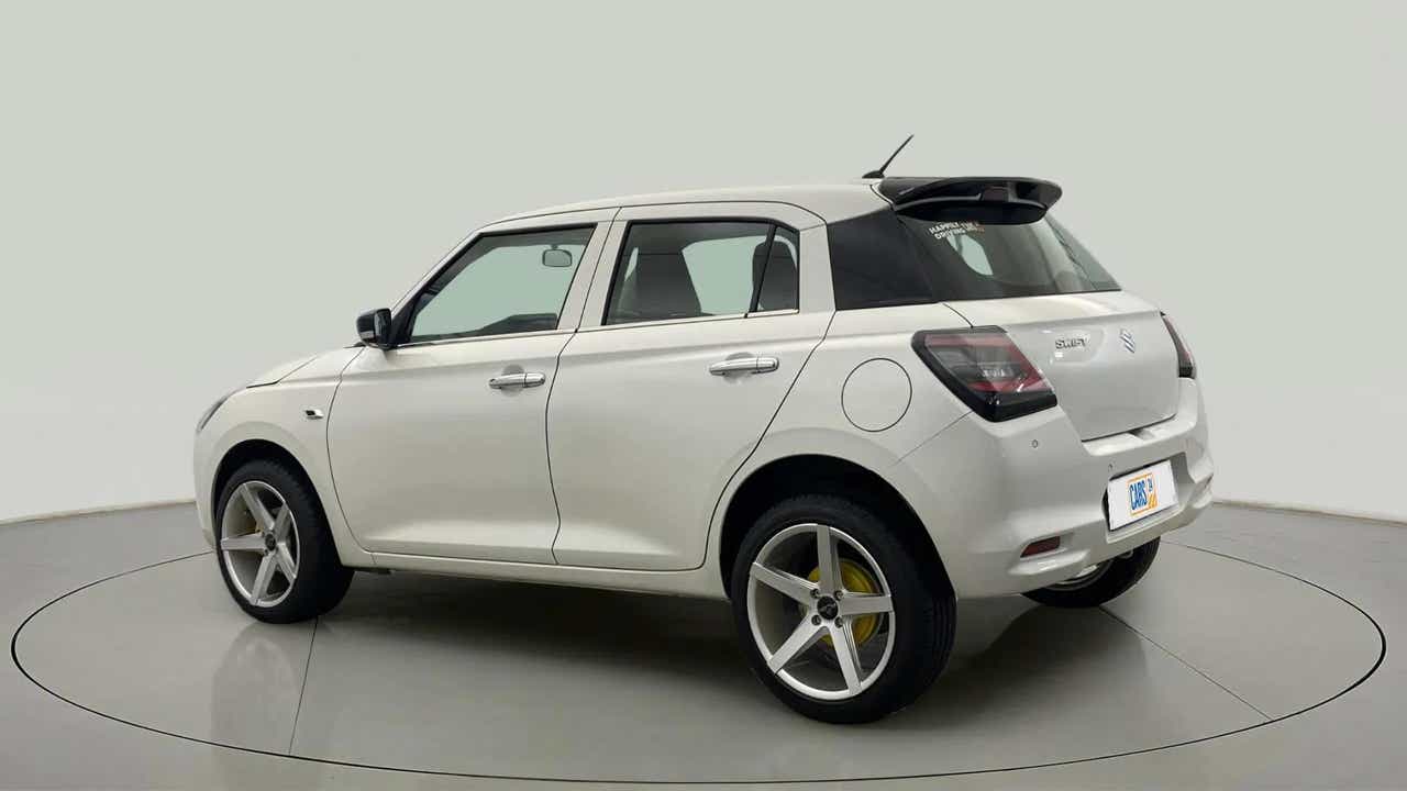 Rear three-quarter view of a Pearl Arctic White with Pearl Midnight Black Maruti Suzuki Swift