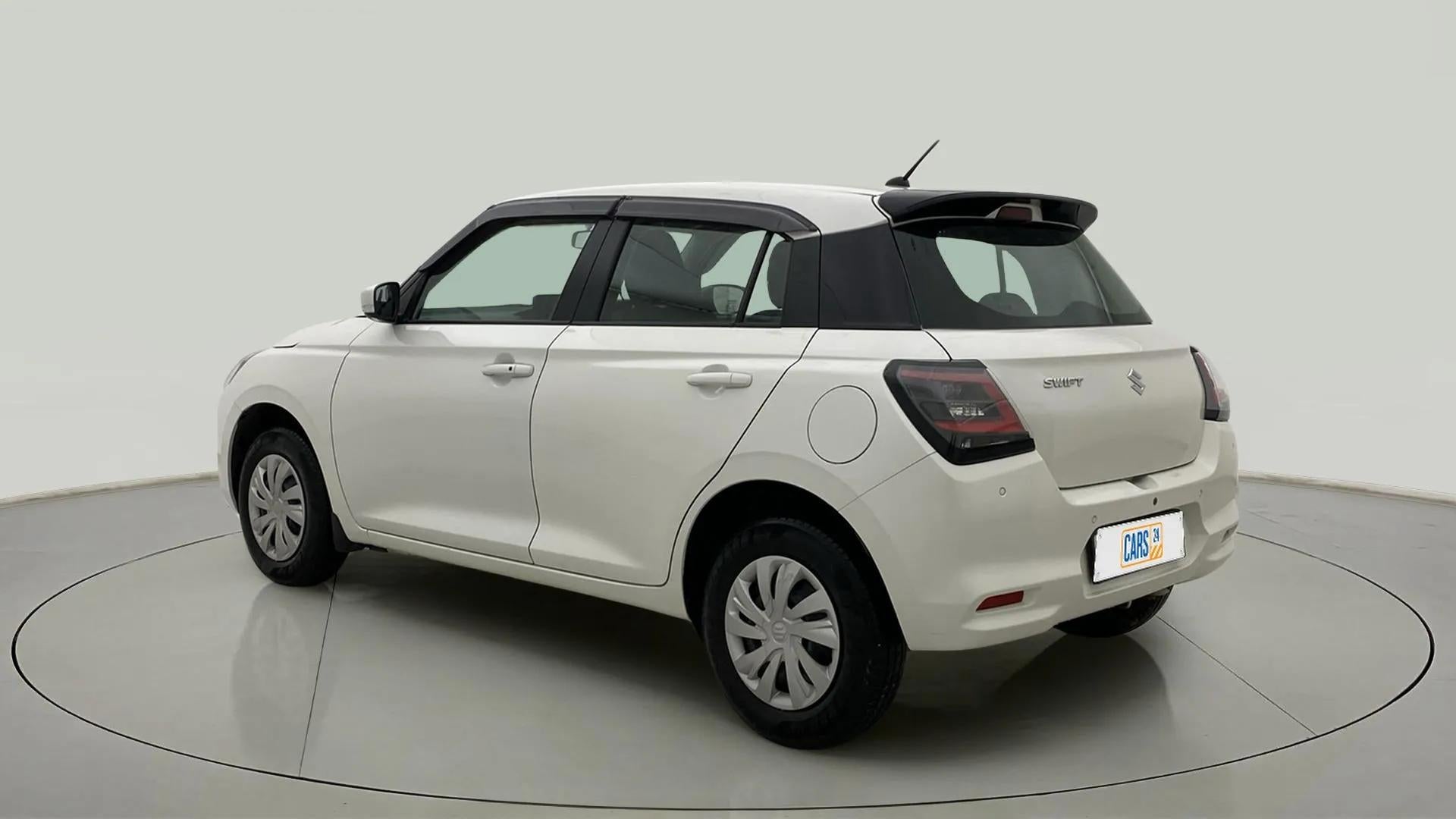 Rear three-quarter of a Pearl Arctic White with Pearl Midnight Black Maruti Suzuki Swift