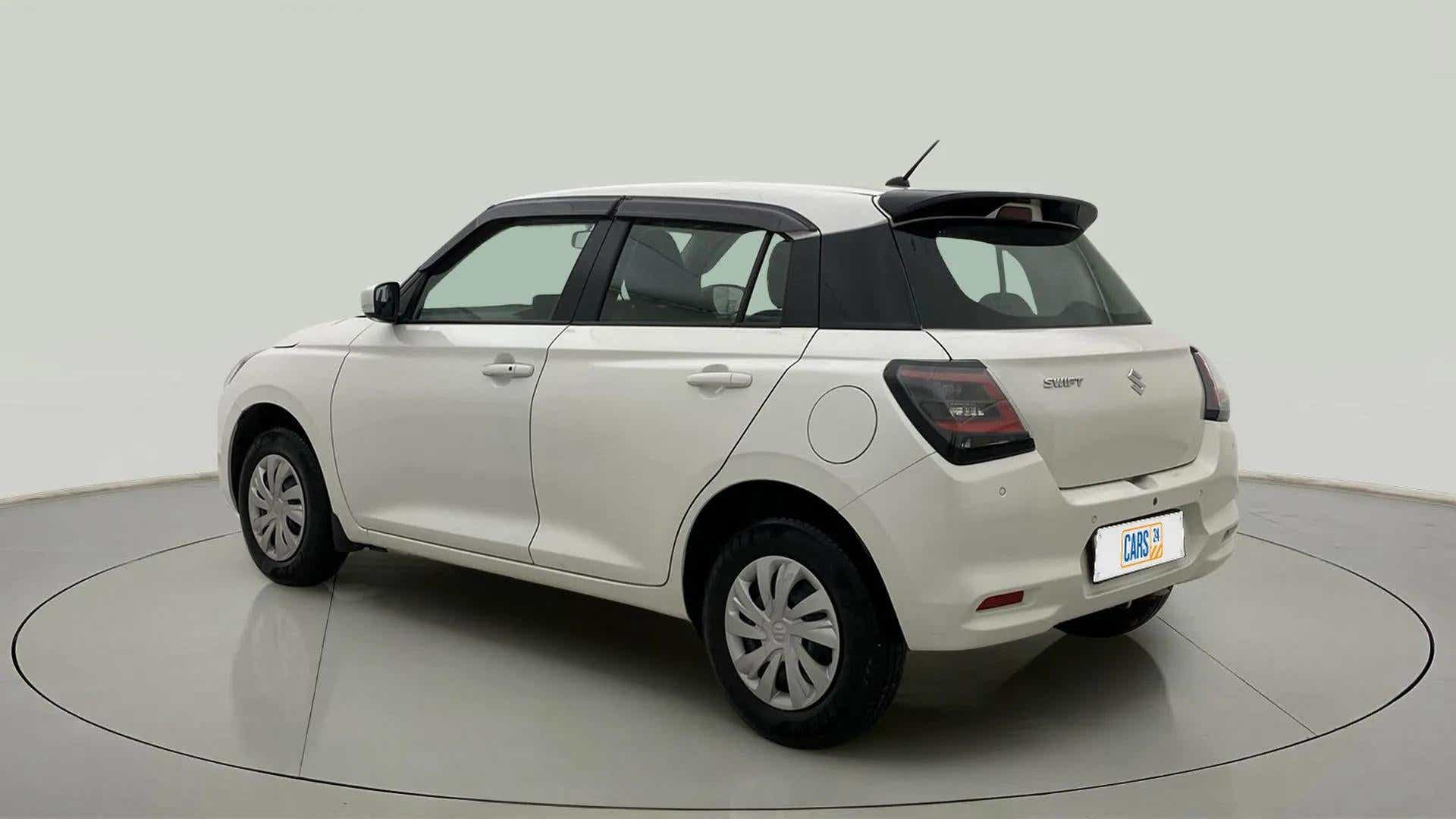 Rear three-quarter of a Pearl Arctic White with Pearl Midnight Black Maruti Suzuki Swift