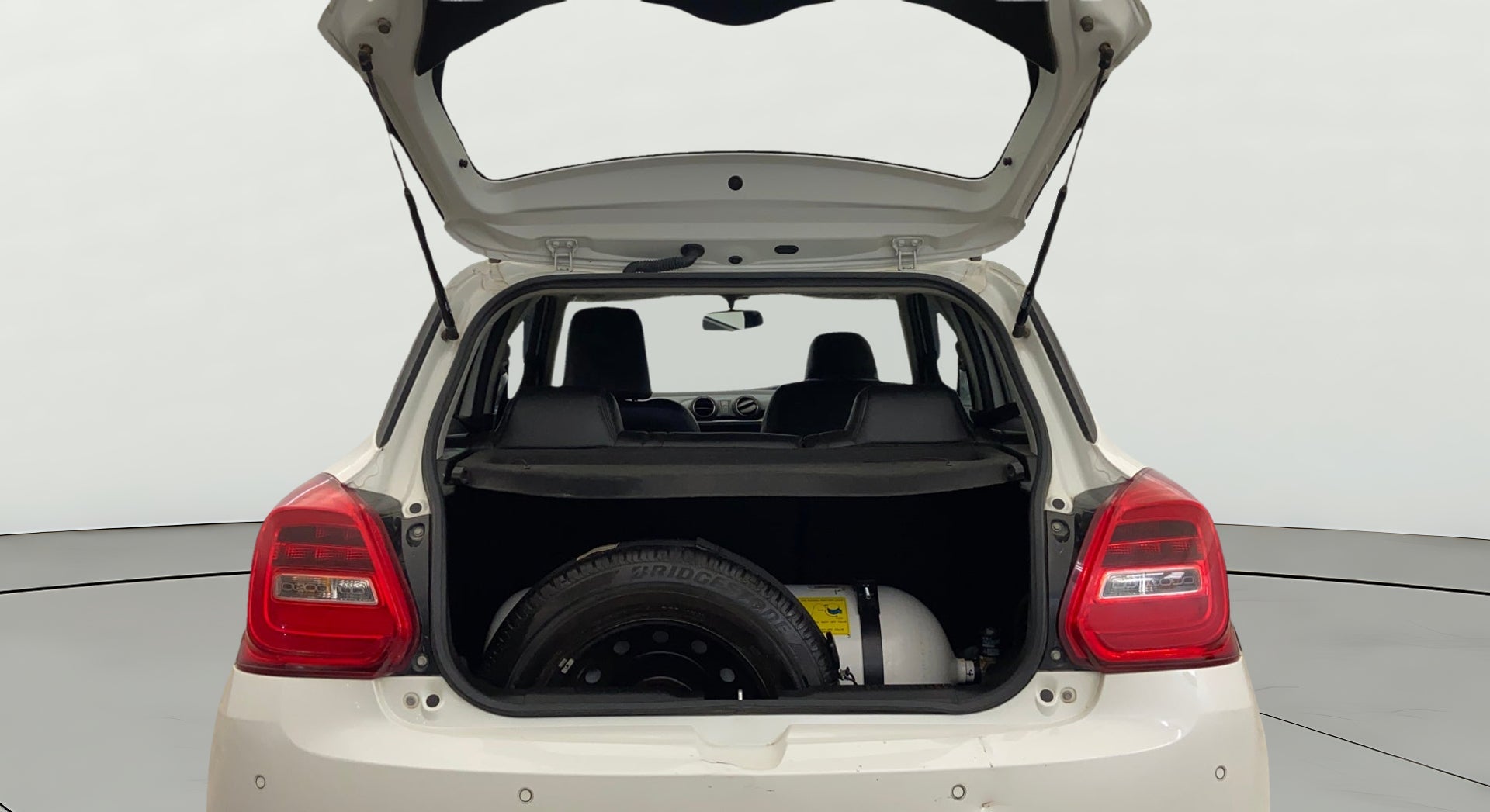 Open boot view of a pearl arctic white Maruti Suzuki Swift