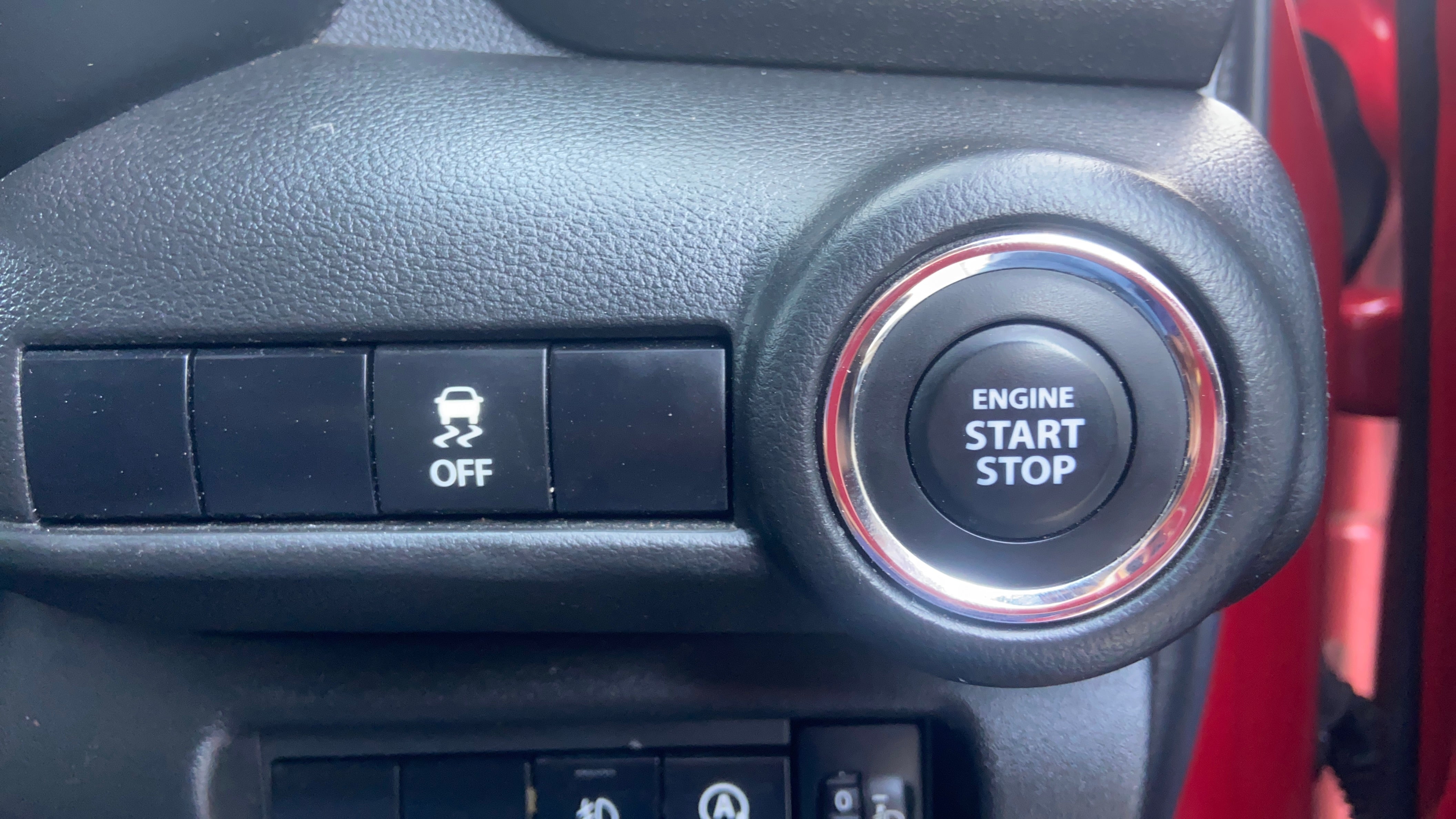 Engine start stop button and traction control switch of a Maruti Suzuki Swift