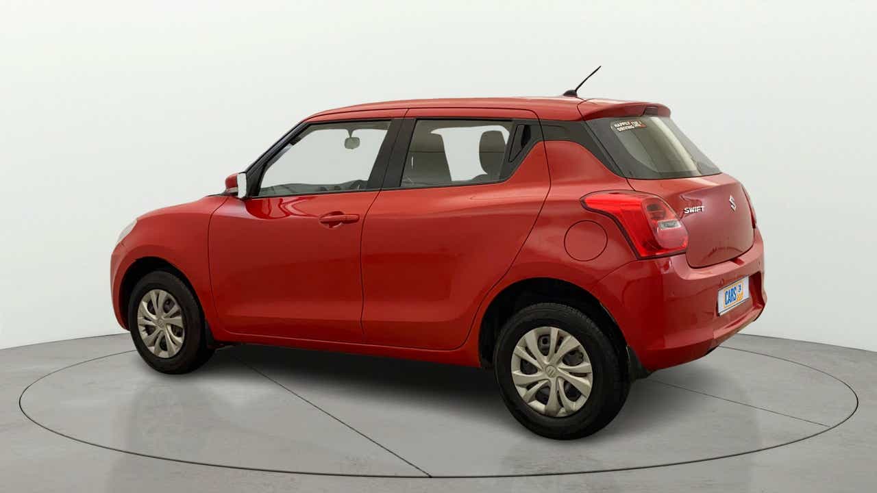 Rear three-quarter view of a solid fire red Maruti Suzuki Swift 2021 - 2023