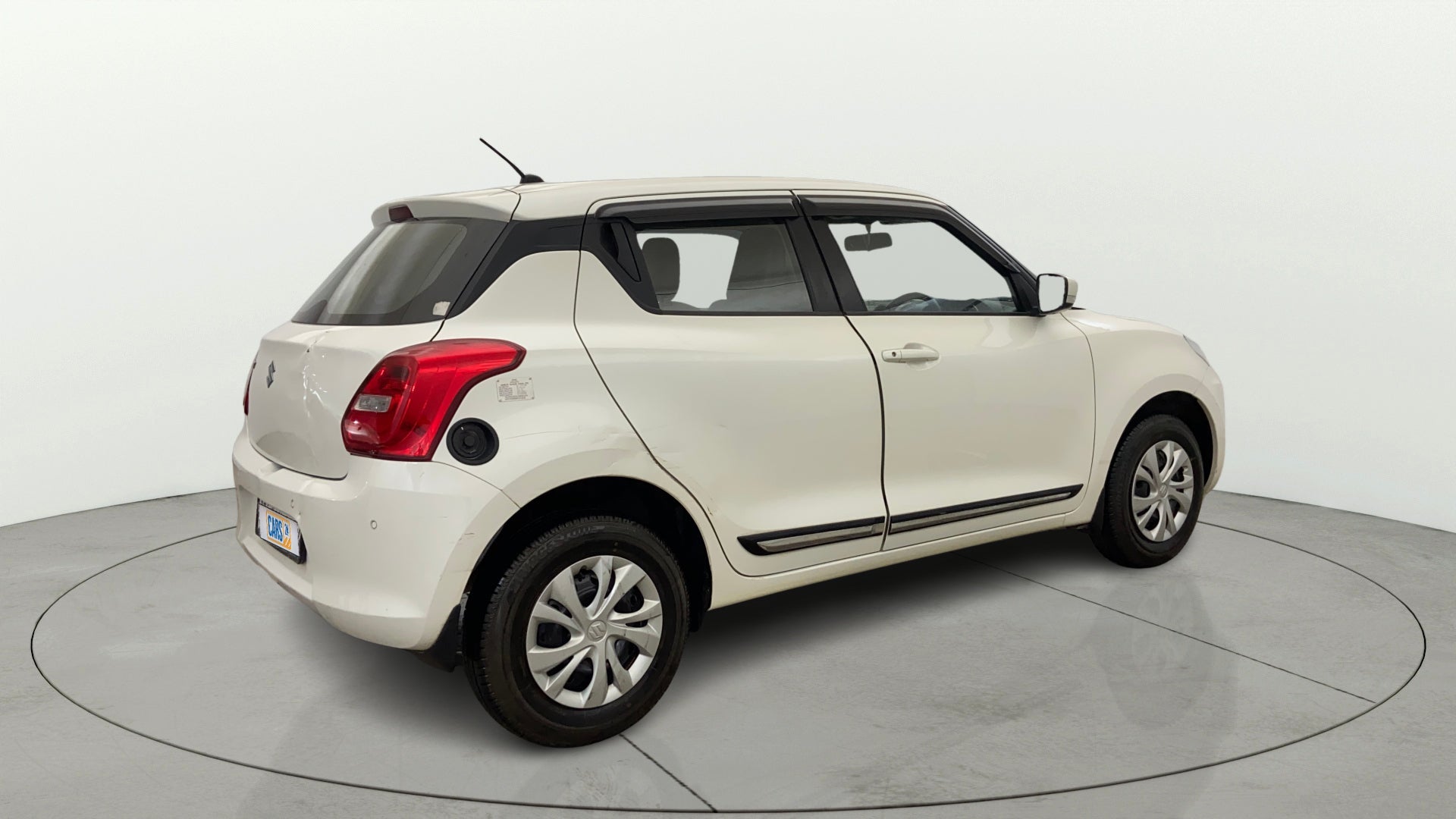 Rear three-quarter view of a Pearl Arctic White with Pearl Midnight Black Maruti Suzuki Swift