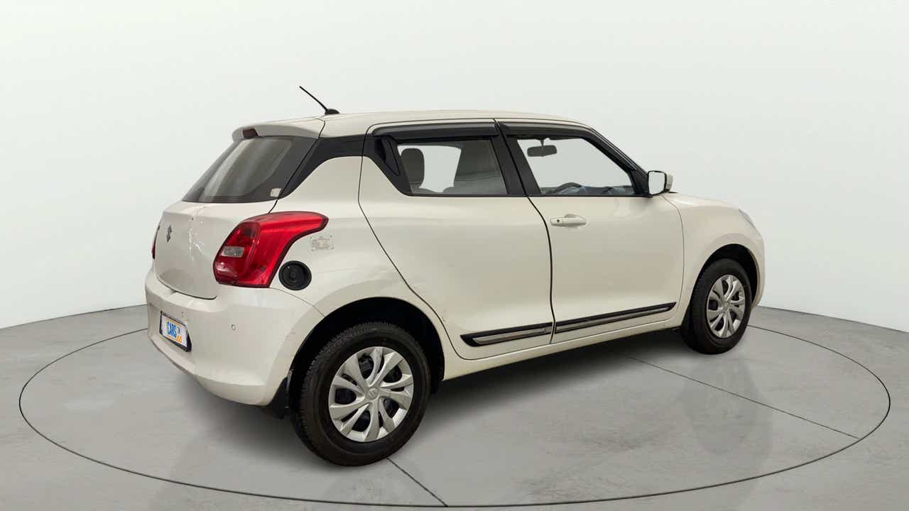 Rear three-quarter view of a Pearl Arctic White with Pearl Midnight Black Maruti Suzuki Swift