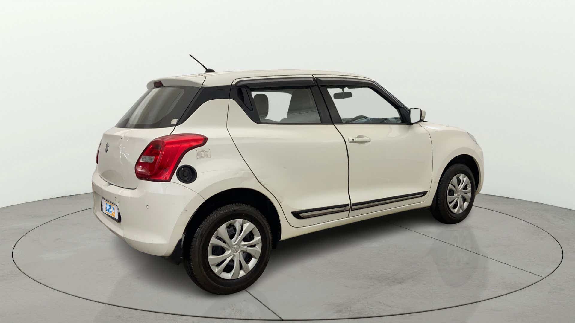 Rear three-quarter view of a Pearl Arctic White with Pearl Midnight Black Maruti Suzuki Swift