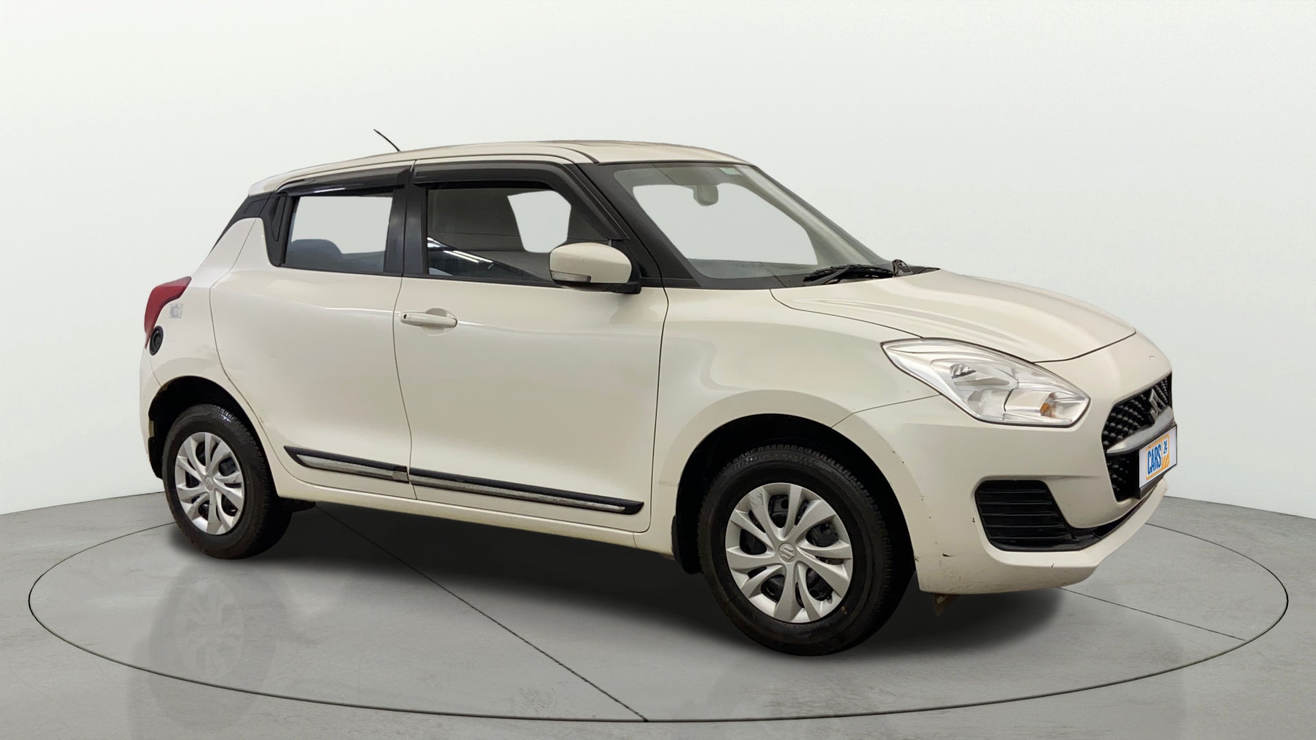 Front three-quarter view of a Pearl Arctic White with Pearl Midnight Black Maruti Suzuki Swift