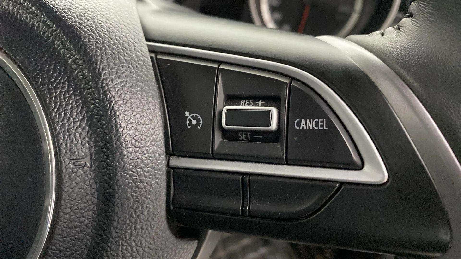 Cruise control buttons on a Maruti Suzuki Swift steering wheel