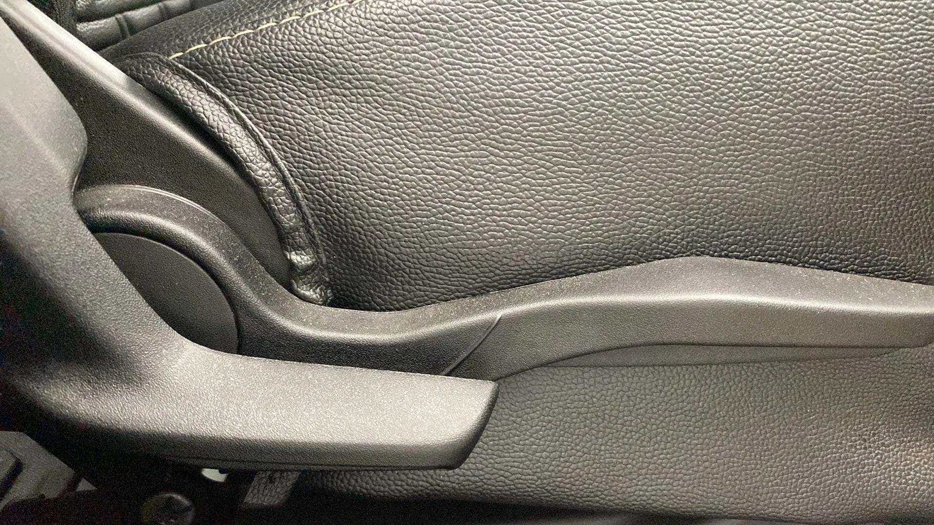 Close-up view of a Maruti Suzuki Swift car seat adjustment lever