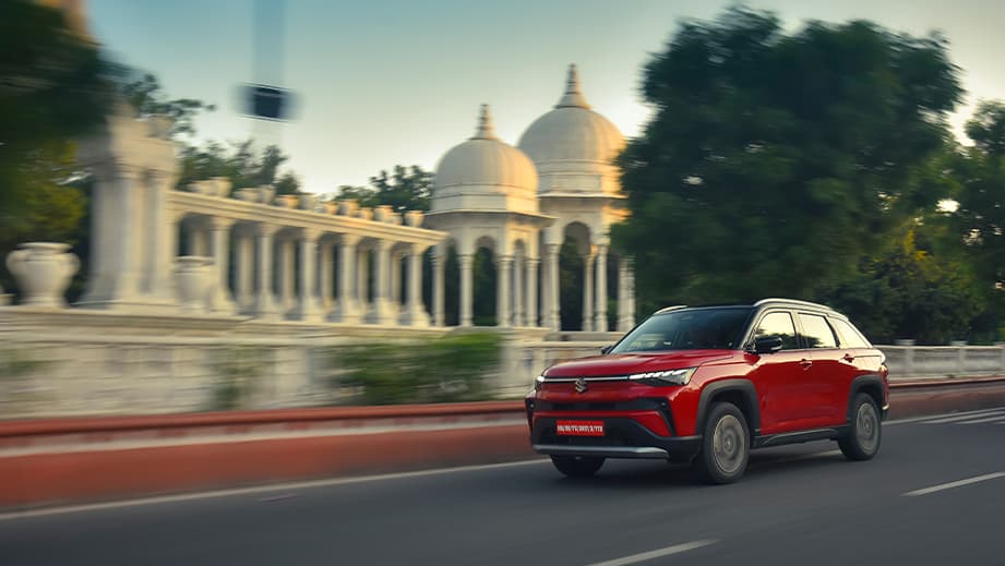 Front three-quarter view of a sizzling red with bluish black roof Maruti Suzuki Victoris