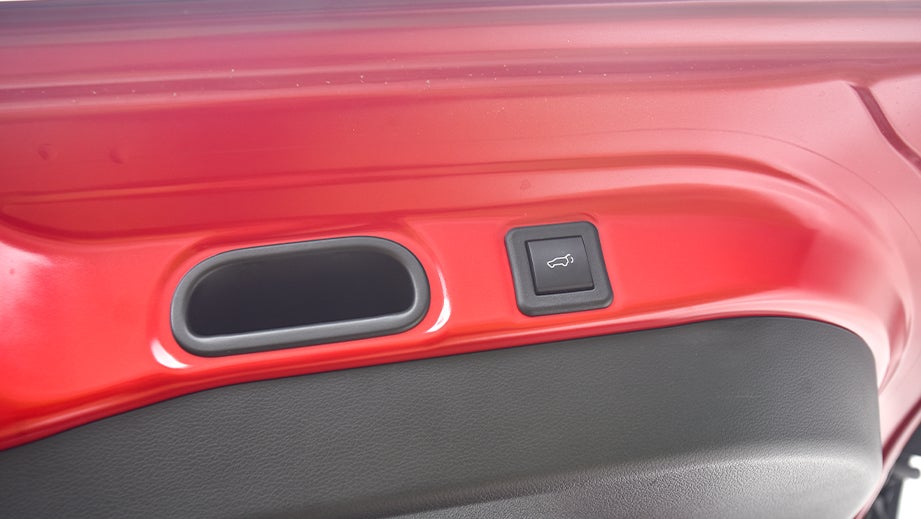 Close-up of trunk release button area of a sizzling red Maruti Suzuki Victoris