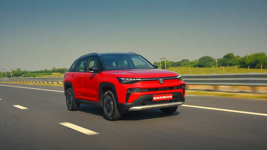 Front three-quarter view of a sizzling red with bluish black roof Maruti Suzuki Victoris