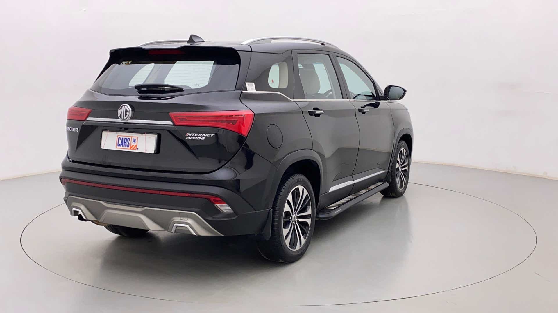 Rear three-quarter view of a starry black MG Hector