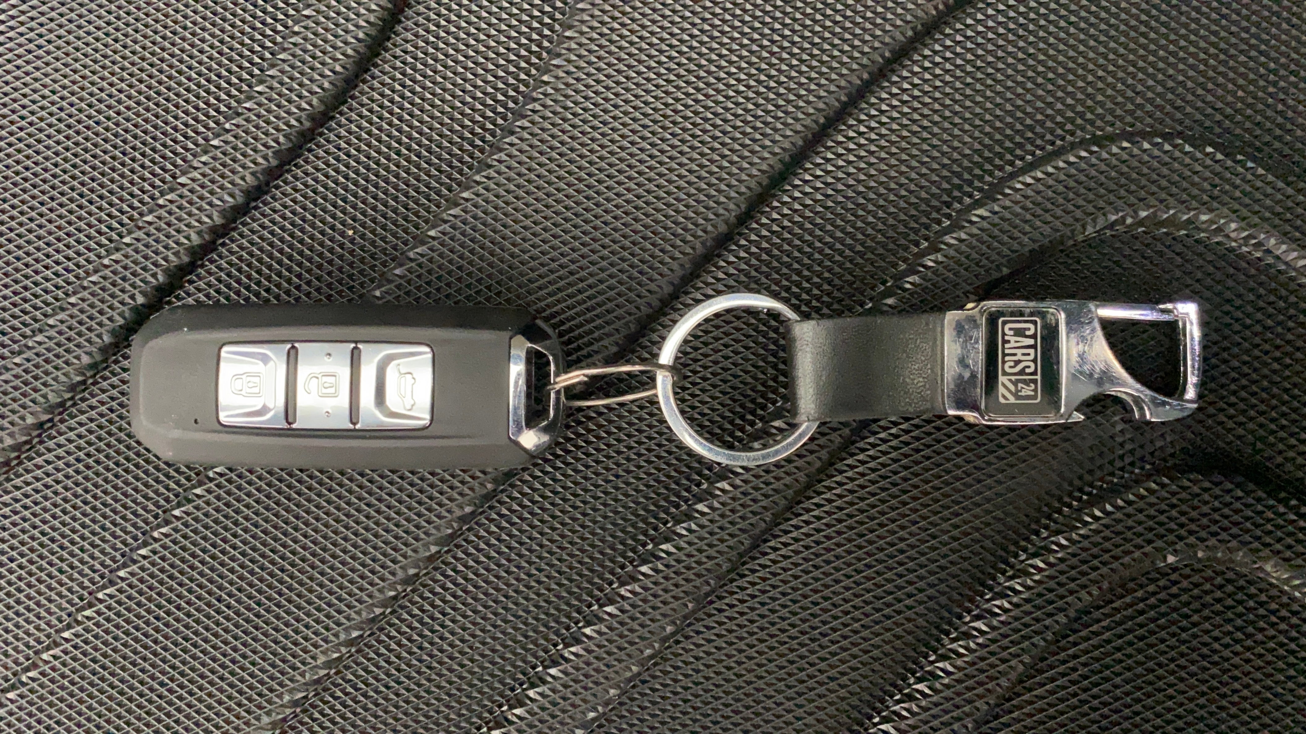 Car key fob with keychain on a textured seat surface of a MG Hector