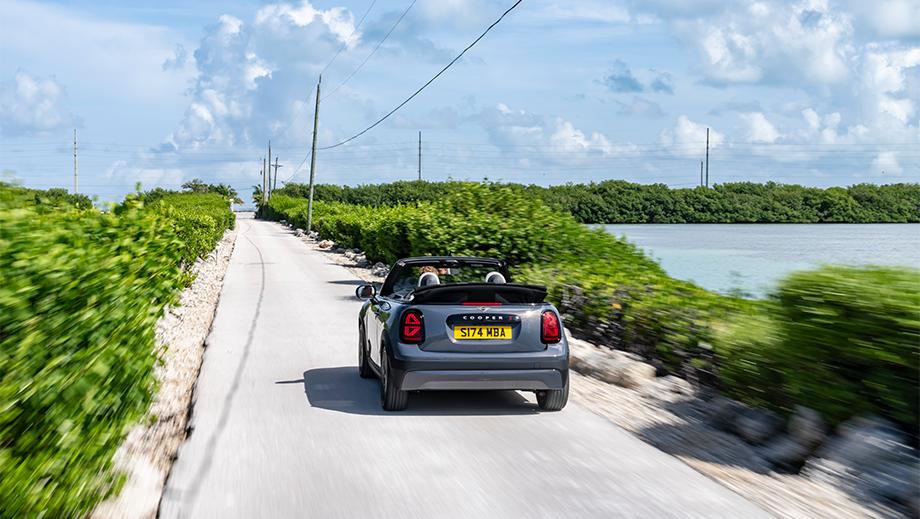 Rear view of a Mini Cooper S Convertible driving on a road