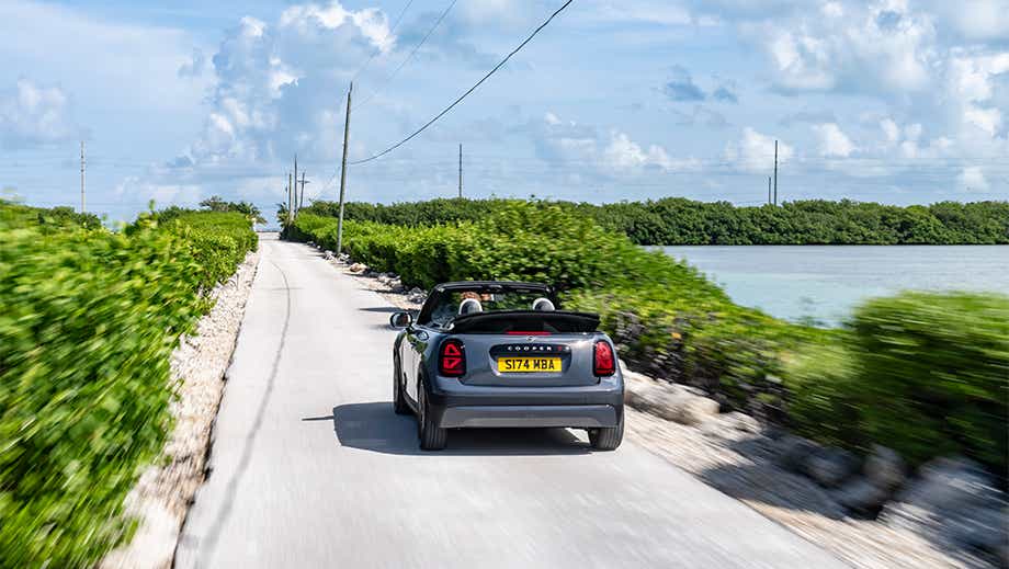 Rear view of a Mini Cooper S Convertible driving on a road