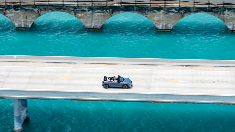 Overhead view of a Mini Cooper S Convertible driving on a bridge