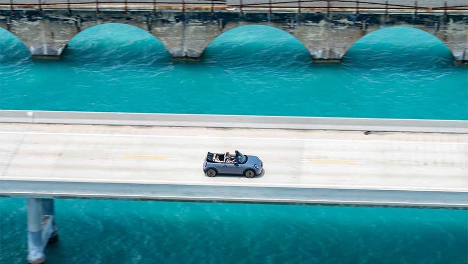 Overhead view of a Mini Cooper S Convertible driving on a bridge