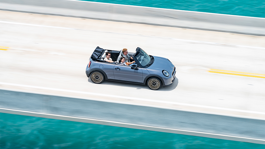 Side view of a Mini Cooper S Convertible driving on a bridge