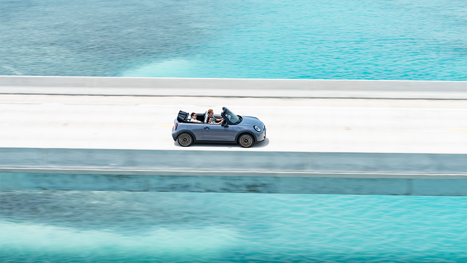 Side view of a Mini Cooper S Convertible driving on a coastal road