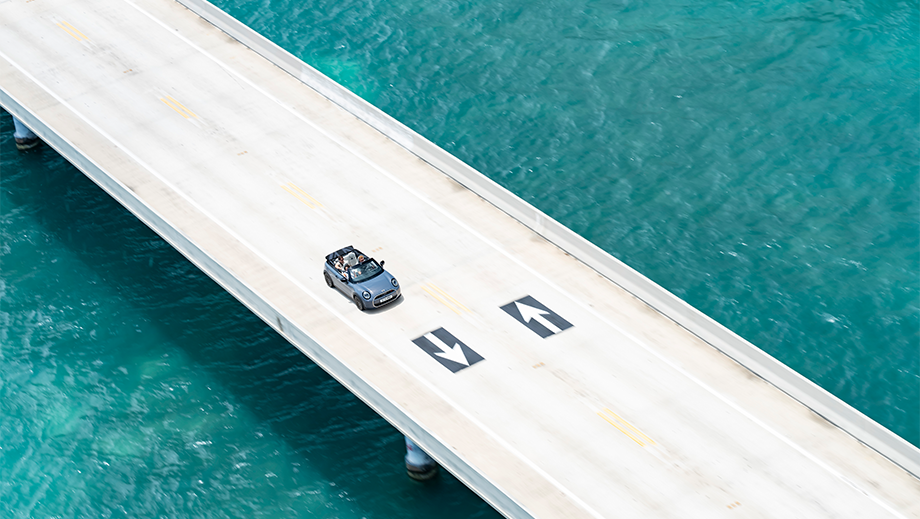 Aerial view of a mini cooper s convertible driving on a bridge