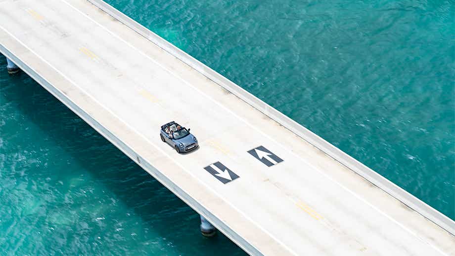 Aerial view of a mini cooper s convertible driving on a bridge