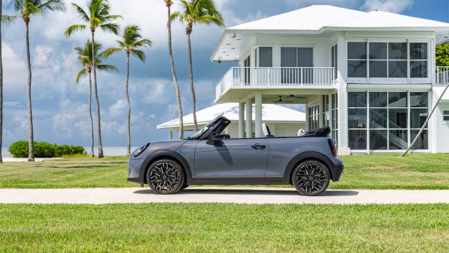 Side view of a Mini Cooper S Convertible near a modern house