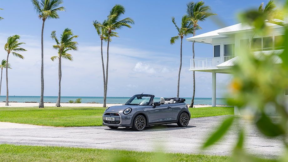 Front three quarter view of a Mini Cooper S Convertible parked near a beach house