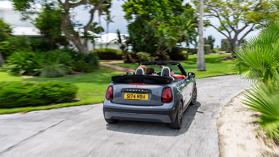 Rear view of a Mini Cooper S Convertible driving on a scenic road