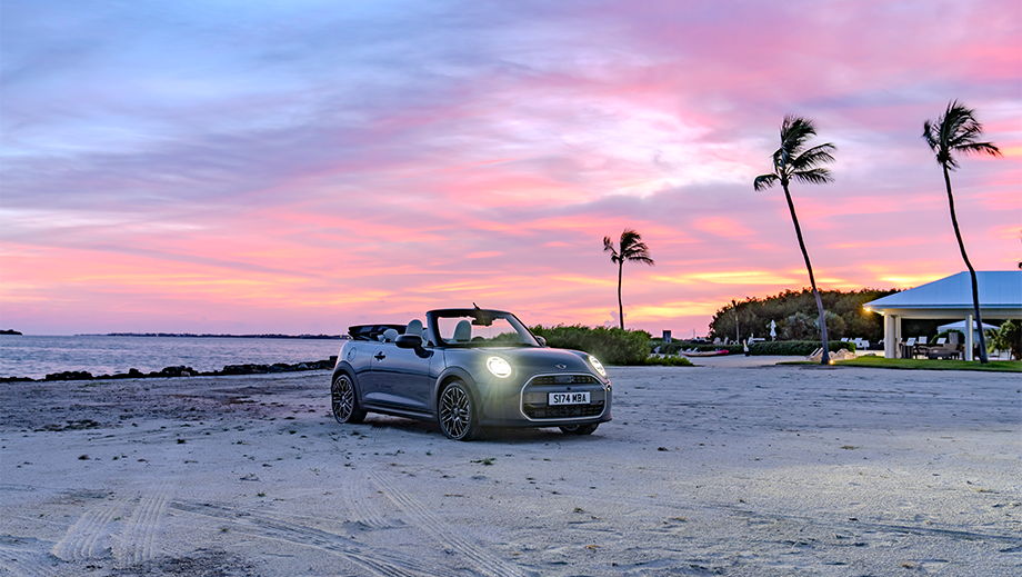 Front three quarter of a Mini Cooper S Convertible on a beach at sunset