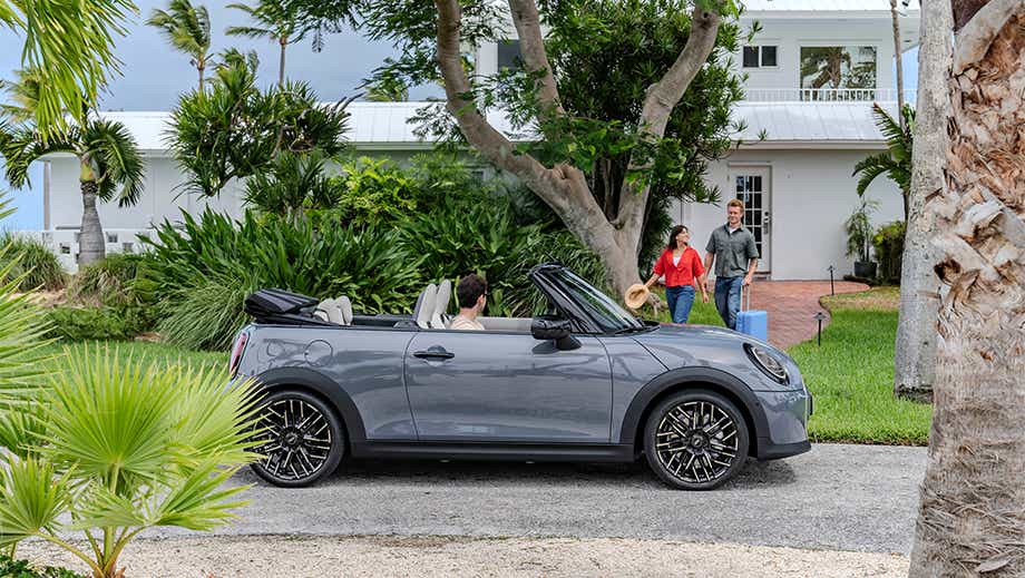 Side view of a Mini Cooper S Convertible parked outside a house