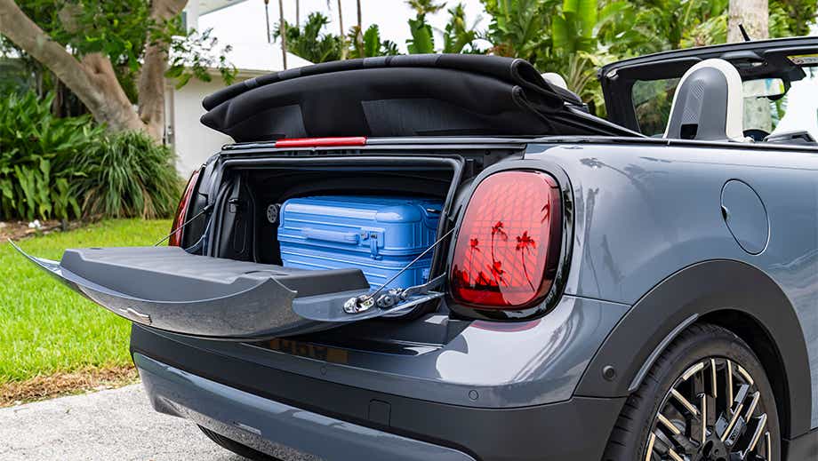 Rear trunk view of a Mini Cooper S Convertible with suitcase