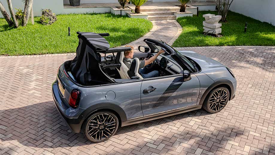 Rear three quarter view of a Mini Cooper S Convertible with convertible roof open