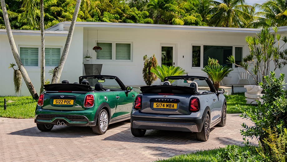 Rear view of a british racing green mini cooper s convertible and another mini cooper s convertible