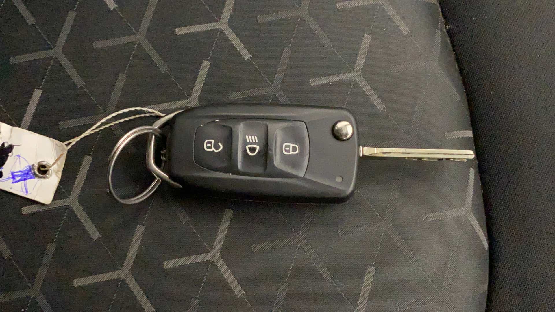 Car key fob on a patterned seat of a Tata Nexon 2017-2023