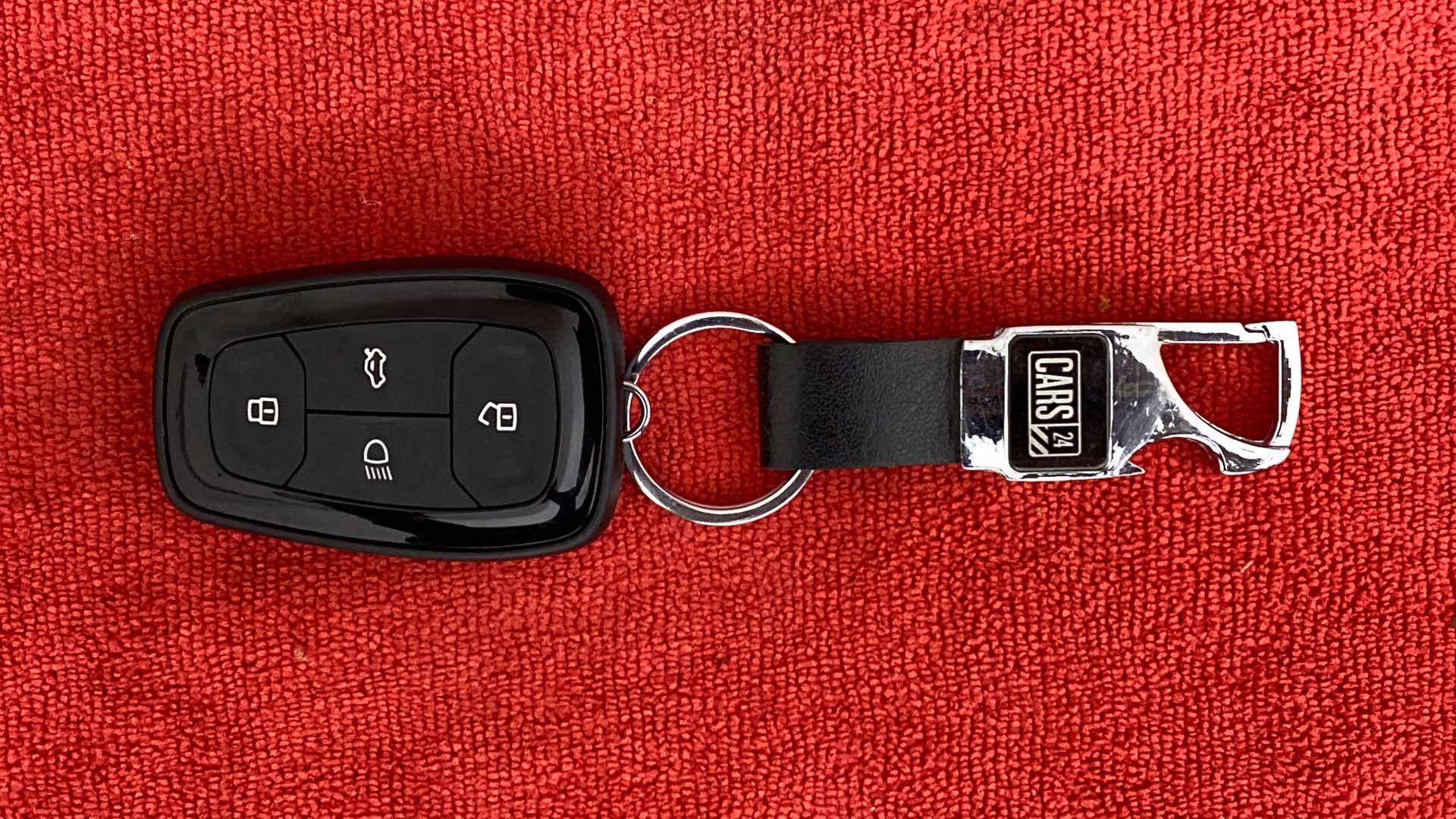 Top view of a Tata Nexon 2017-2023 car key on a red background